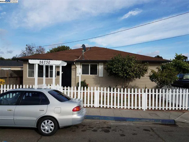 a car parked in front of a white house