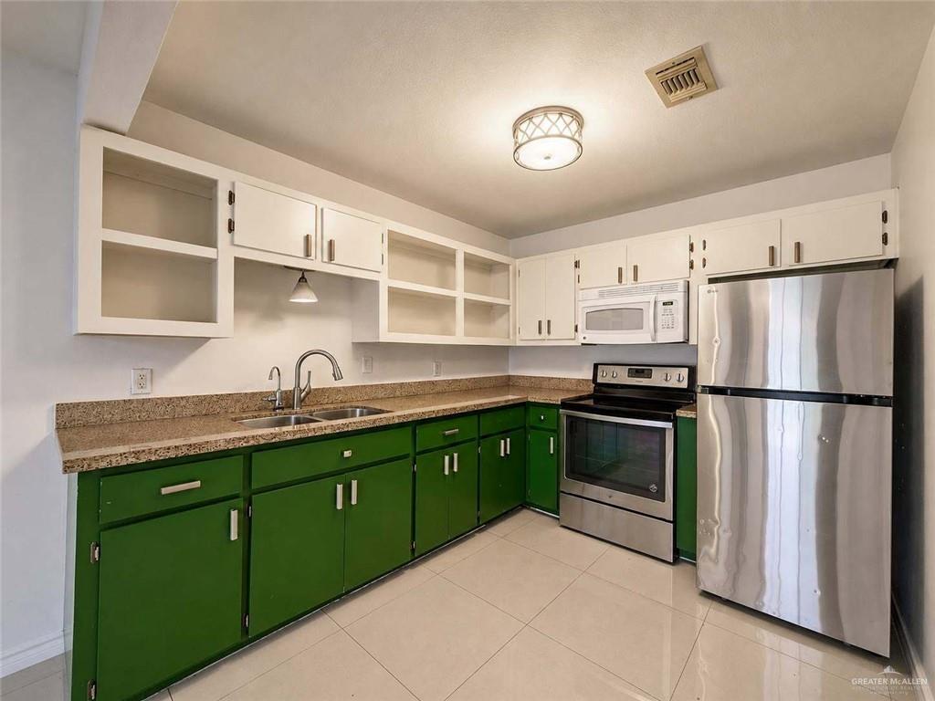 2201 South Jackson Road, Unit 2I Pharr, TX 78577 - Photo 7 of 23 Kitchen featuring a double basin stainless steel sink, wood-finish countertops, white upper cabinetry, and green lower cabinetry
