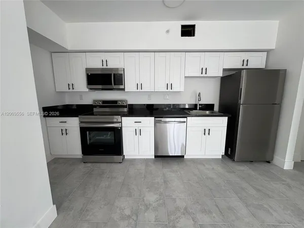 a kitchen with stainless steel appliances granite countertop a stove a sink and a refrigerator