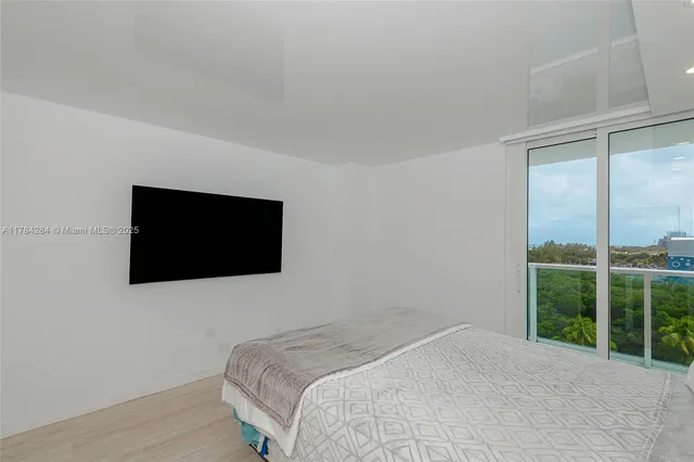 a bed sitting in a spacious bedroom next to a window