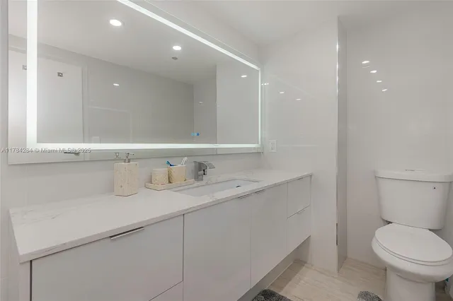 a bathroom with a granite countertop sink a toilet and bathtub