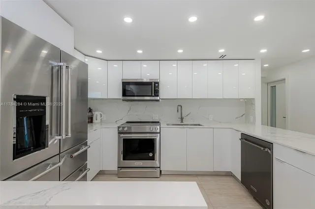 a kitchen with stainless steel appliances granite countertop a refrigerator sink and stove