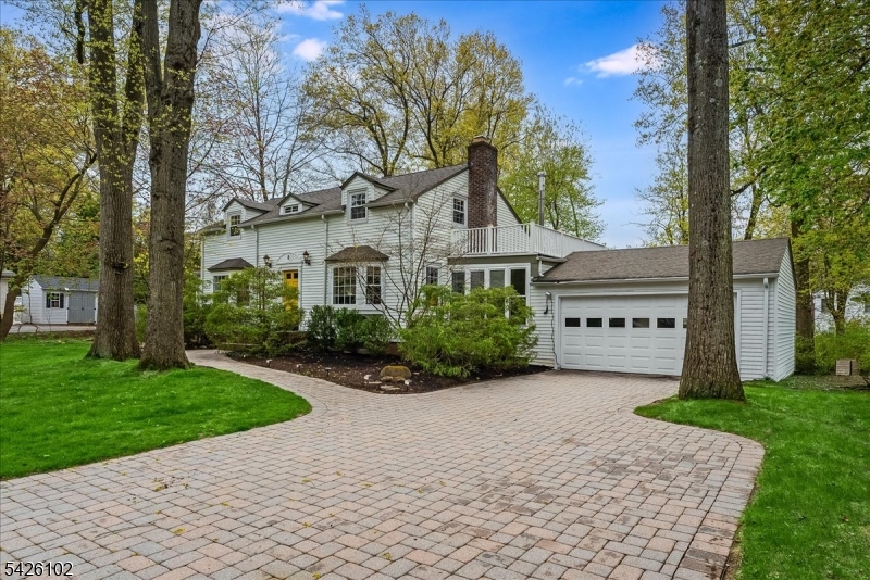 a view of a house with a yard and large trees