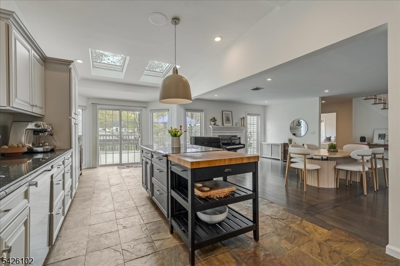 8 Lessing Road West Orange, NJ 07052 - Photo 11 of 40 a kitchen with stainless steel appliances granite countertop a stove a sink a dining table and chairs with wooden floor