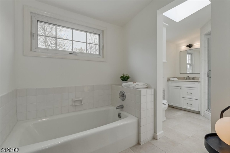 8 Lessing Road West Orange, NJ 07052 - Photo 22 of 40 a bathroom with a bathtub a toilet a sink and a window