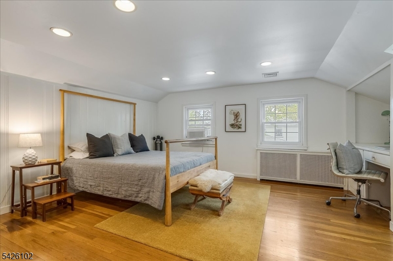 8 Lessing Road West Orange, NJ 07052 - Photo 26 of 40 a bedroom with a bed a table and a dresser with wooden floor