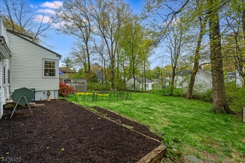 8 Lessing Road West Orange, NJ 07052 - Photo 32 of 40 a view of a backyard with table and chairs under a large tree