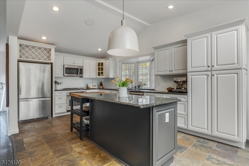 8 Lessing Road West Orange, NJ 07052 - Photo 7 of 40 a kitchen with kitchen island granite countertop a refrigerator a sink dishwasher a stove and white cabinets with wooden floor