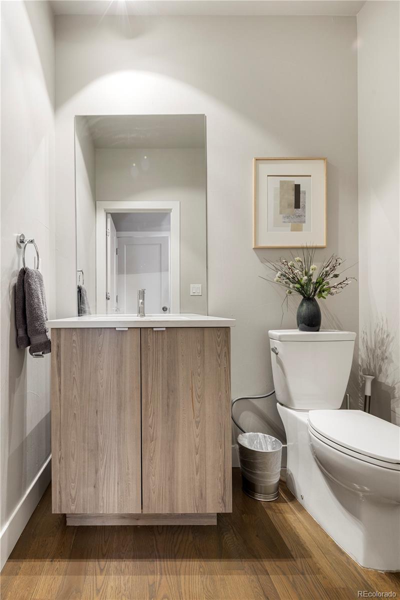 1815 Grove Street Denver, CO 80204 - Photo 14 of 36 a bathroom with a toilet a sink and mirror