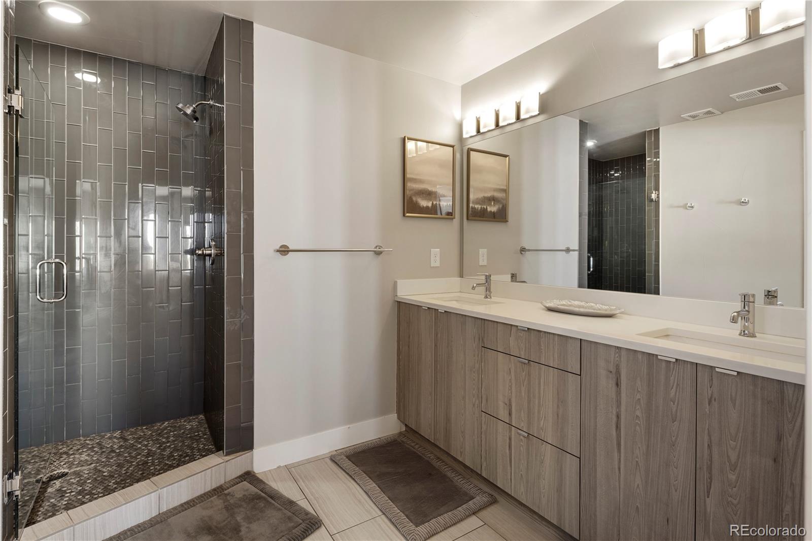 1815 Grove Street Denver, CO 80204 - Photo 17 of 36 a bathroom with a double vanity sink and a mirror