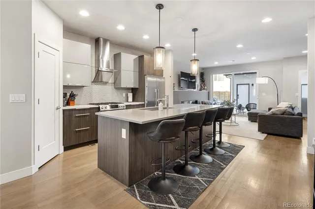 a kitchen with stainless steel appliances granite countertop a sink a stove and a refrigerator