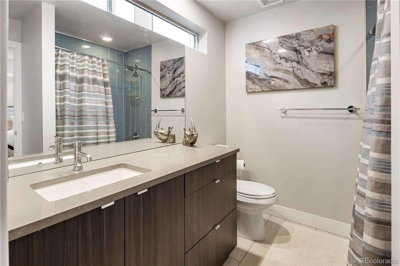 1815 Grove Street Denver, CO 80204 - Photo 21 of 36 a bathroom with a sink a toilet and shower curtain