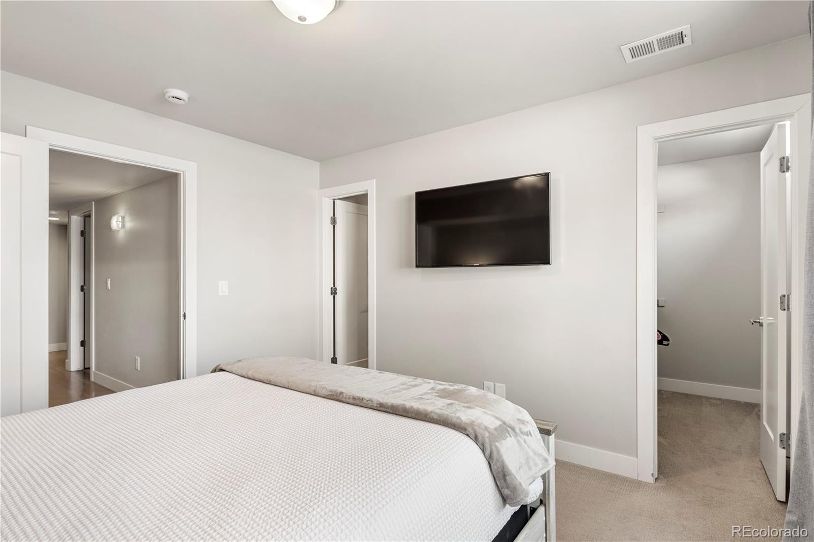 1815 Grove Street Denver, CO 80204 - Photo 23 of 36 a bedroom with a bed and a flat screen tv