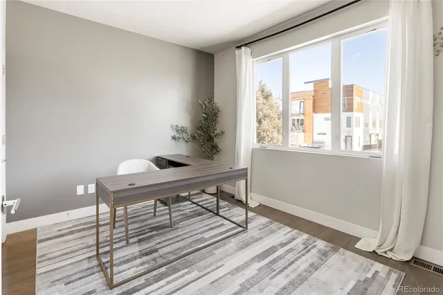 a workspace room with furniture and window