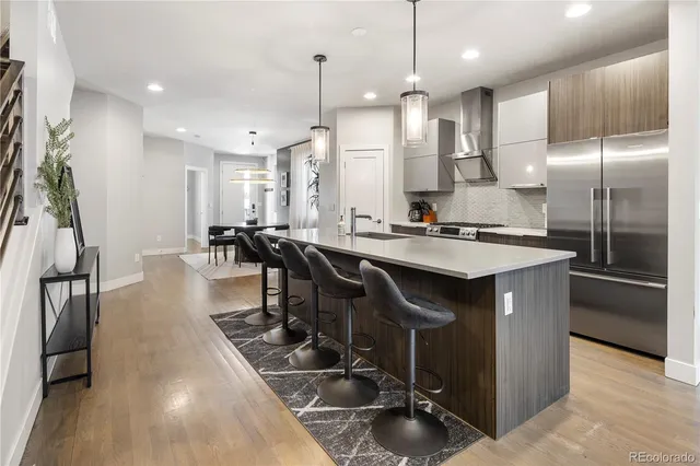 a kitchen with stainless steel appliances granite countertop a sink a stove and a refrigerator