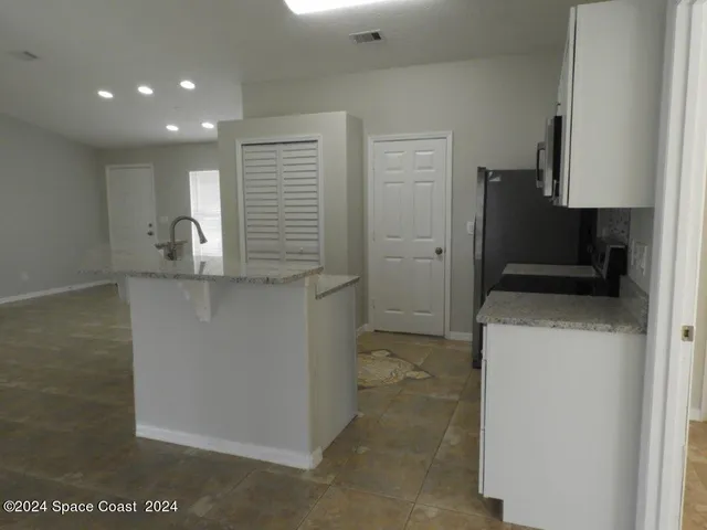a kitchen with a refrigerator and a sink