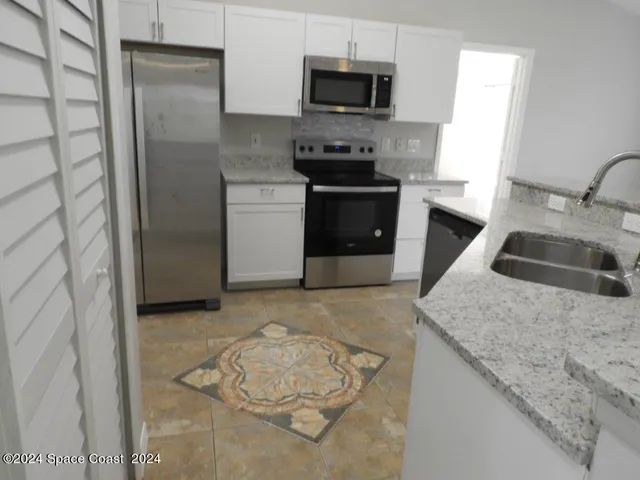 a kitchen with a sink stove and refrigerator