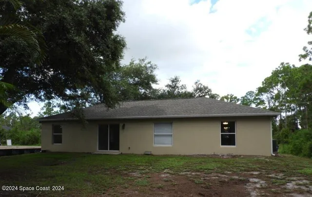 a house with lots of trees in the background