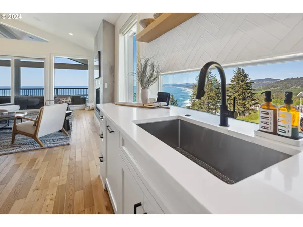 a living room with stainless steel appliances kitchen island granite countertop a sink and a granite counter tops