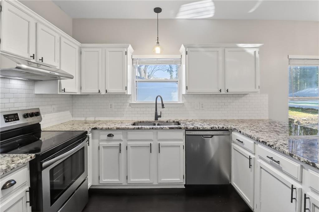 991 Ada Avenue Northwest Atlanta, GA 30318 - Photo 11 of 32 a kitchen with stainless steel appliances granite countertop a sink stove and cabinets