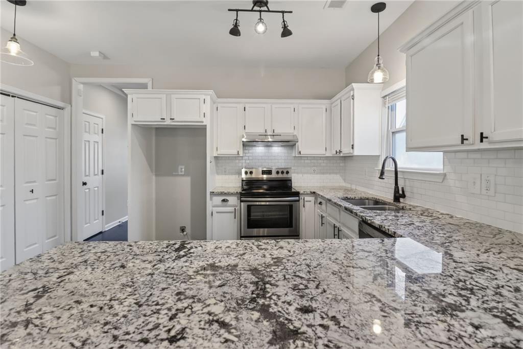 991 Ada Avenue Northwest Atlanta, GA 30318 - Photo 14 of 32 a kitchen with granite countertop a stove sink and refrigerator