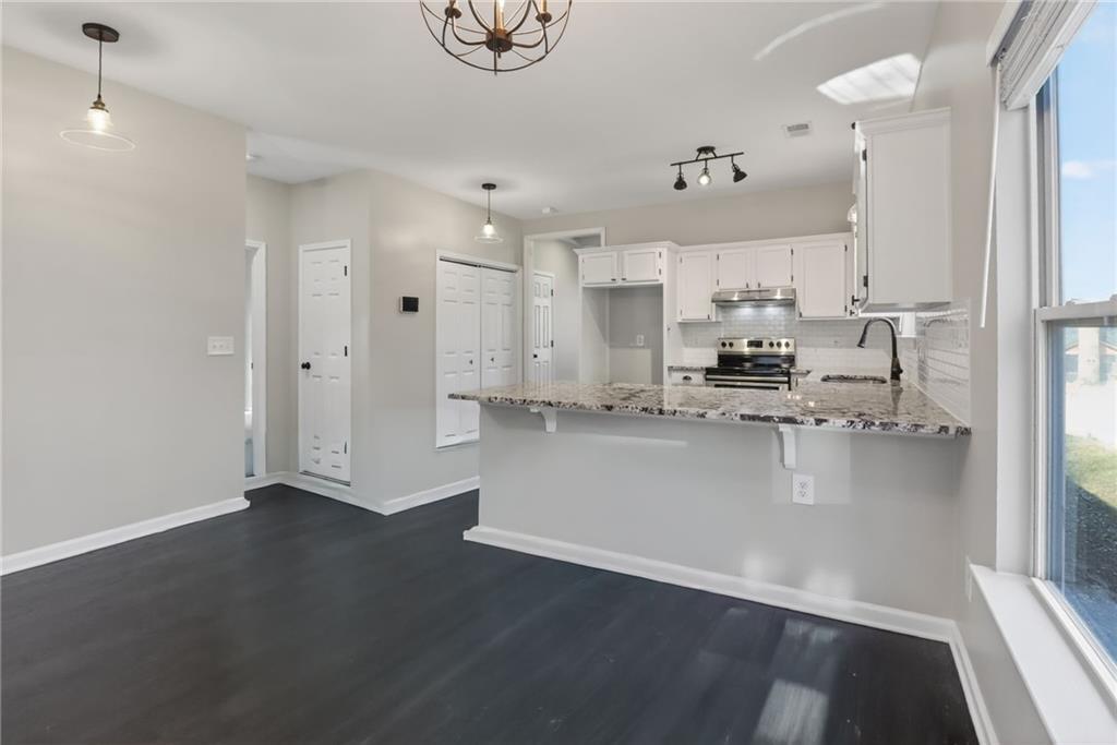 991 Ada Avenue Northwest Atlanta, GA 30318 - Photo 15 of 32 a view of kitchen with stainless steel appliances granite countertop a refrigerator a stove and a sink with wooden floor