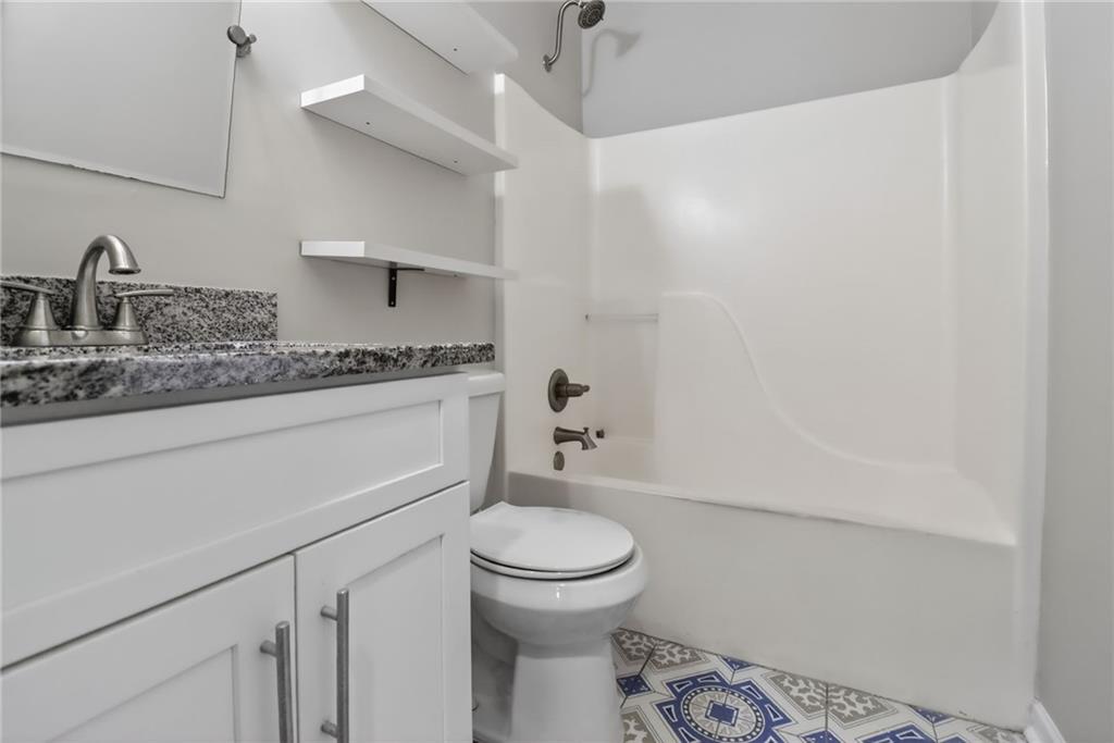 991 Ada Avenue Northwest Atlanta, GA 30318 - Photo 25 of 32 a bathroom with a granite countertop toilet sink and mirror