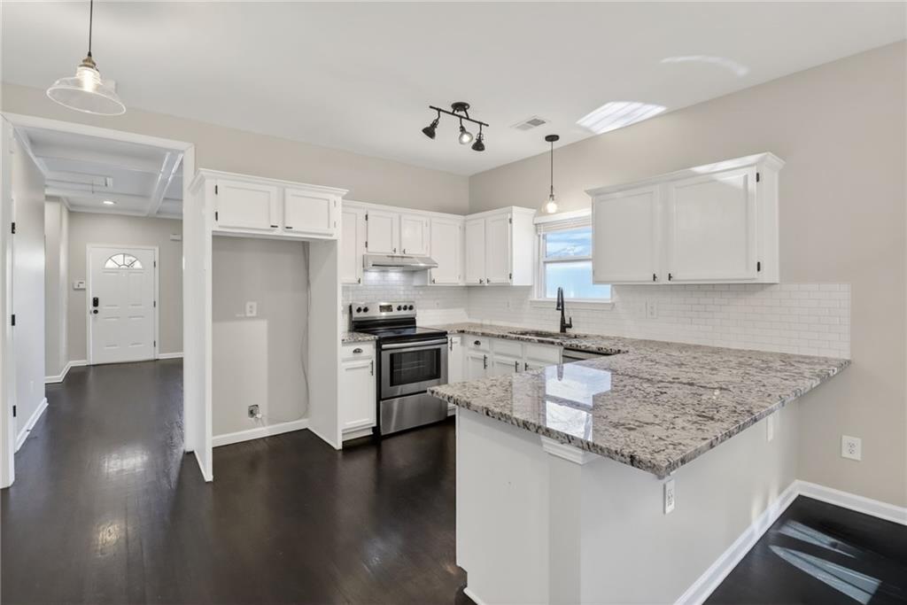 991 Ada Avenue Northwest Atlanta, GA 30318 - Photo 9 of 32 a kitchen with granite countertop a sink cabinets and stainless steel appliances