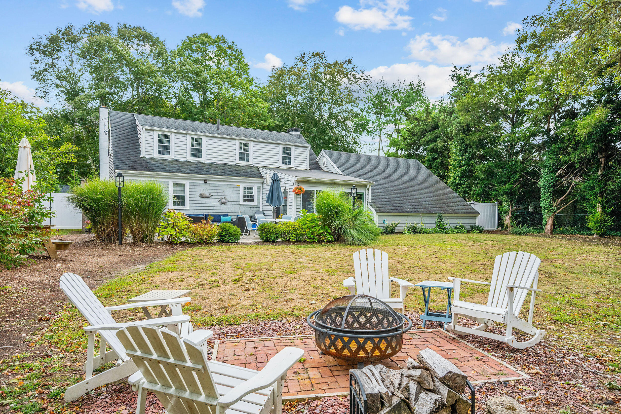 442 Pine Street Centerville, MA 02632 - Photo 29 of 43 a view of a patio with table and chairs potted plants and large tree