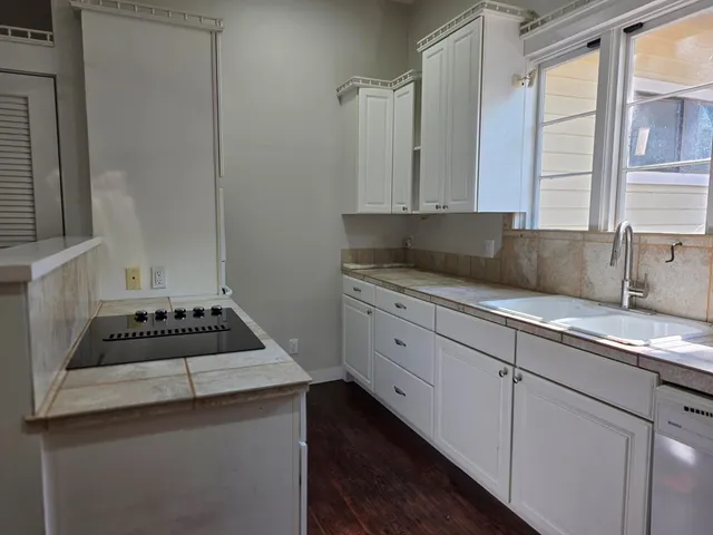 a kitchen with sink a stove and cabinets