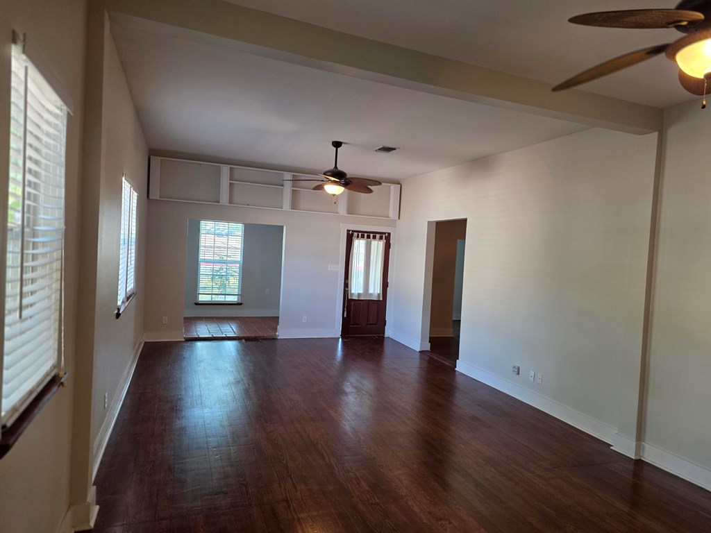 109 West Travis Street, Unit MH Fredericksburg, TX 78624 - Photo 3 of 24 a view of an empty room with wooden floor and a window