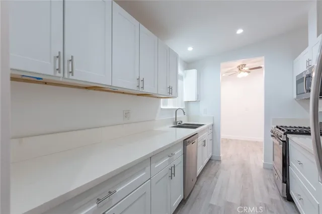 a kitchen with granite countertop white cabinets and white appliances