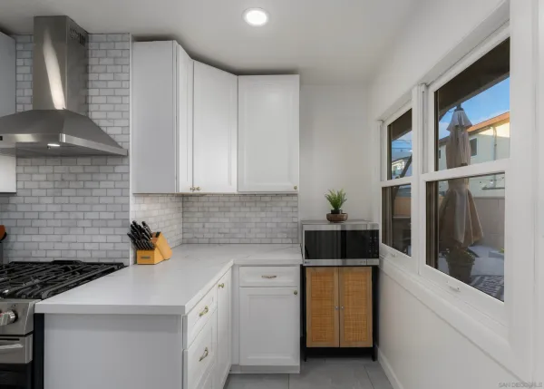 a kitchen with a stove and white cabinets