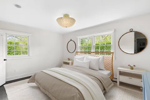 a bedroom with a bed and a large window