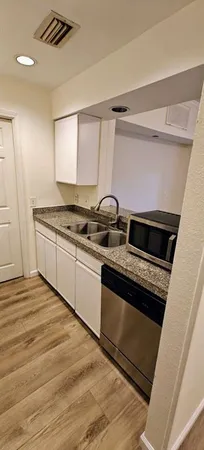 a kitchen with granite countertop a stove and a sink