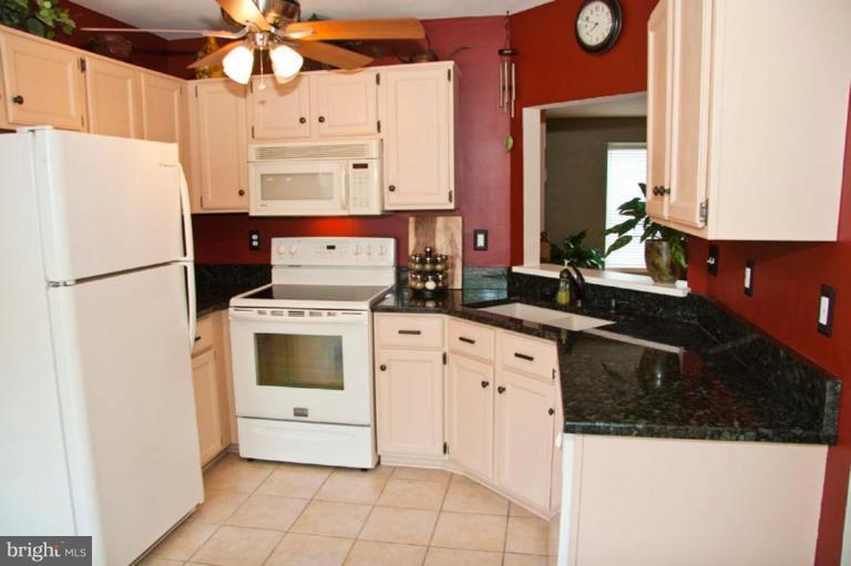 4440 Cole Farm Road Nottingham, MD 21236 - Photo 9 of 26 a kitchen with granite countertop a white stove top oven and refrigerator
