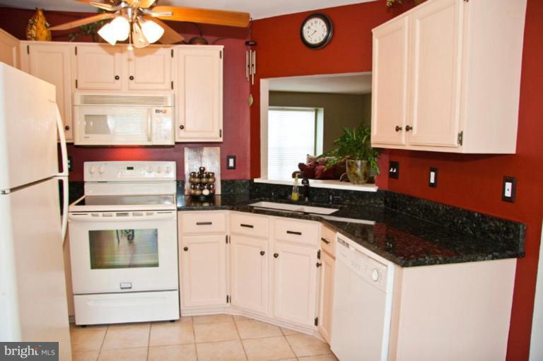 4440 Cole Farm Road Nottingham, MD 21236 - Photo 10 of 26 a kitchen with white cabinets and white appliances
