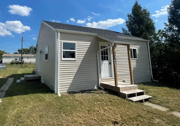 a backyard of a house with barbeque oven and outdoor seating