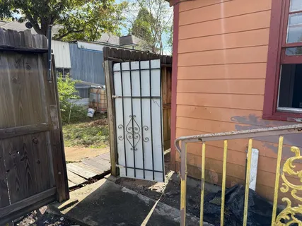 a view of a house with a floor to ceiling window and wooden fence