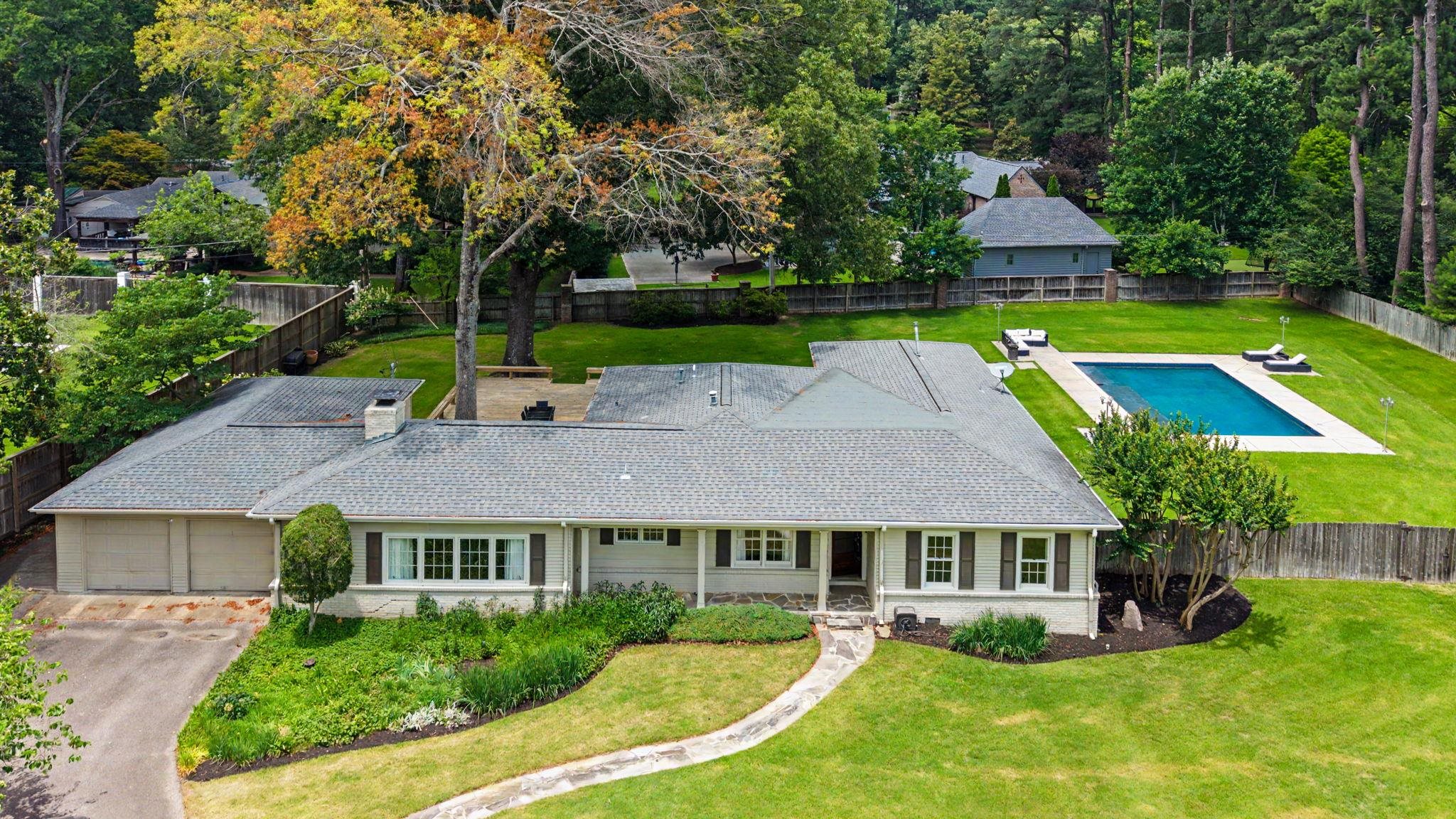 5360 Revere Road Memphis, TN 38120 - Photo 3 of 40 Ranch-style residence featuring a prominent front lawn, a swimming pool with surrounding hardscaping, a stone pathway, and an attached two-car garage