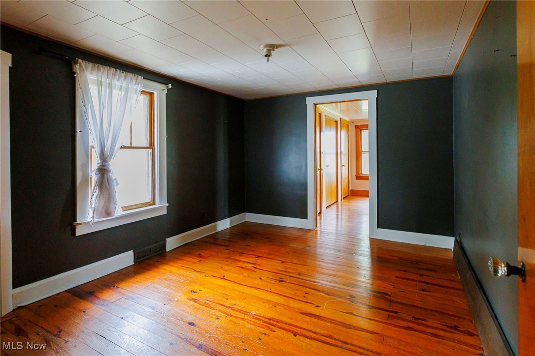 7997 Chestnut Ridge Road Northwest Beach City, OH 44608 - Photo 9 of 31 Empty room with hardwood / wood-style flooring and baseboards