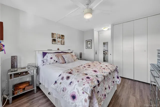 a bedroom with a large bed and a flat tv screen on dresser