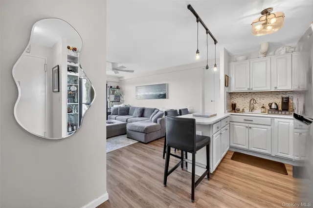a kitchen with wooden floor and white cabinets