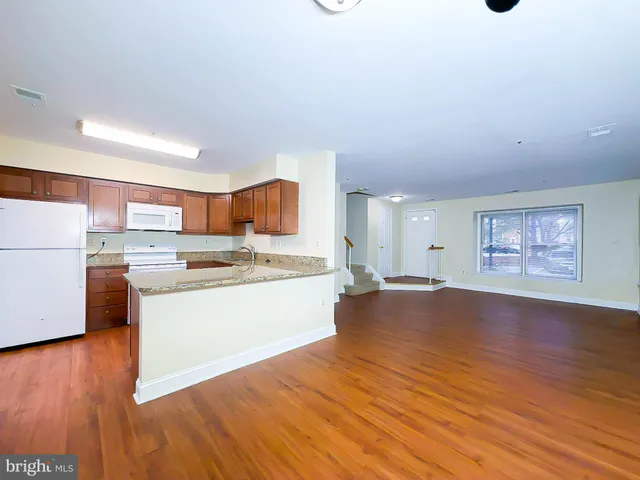 a view of kitchen with wooden floor and electronic appliances