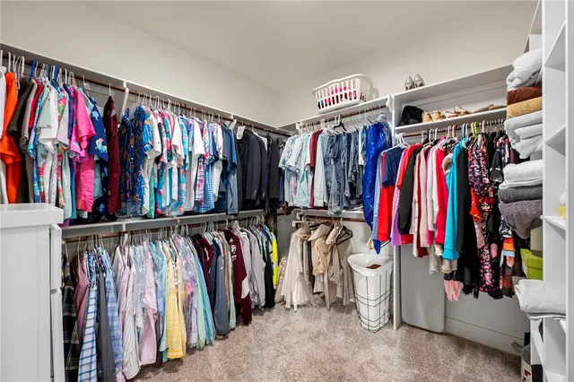 a view of walk in closet with clothes