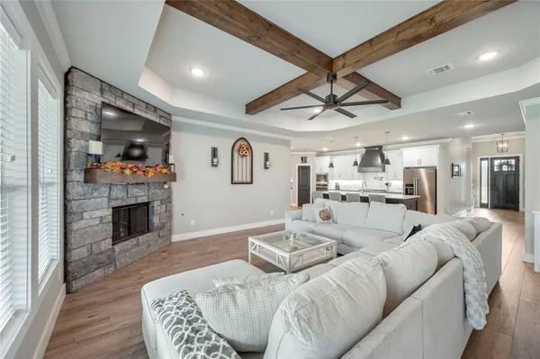 a living room with furniture a fireplace and a kitchen view