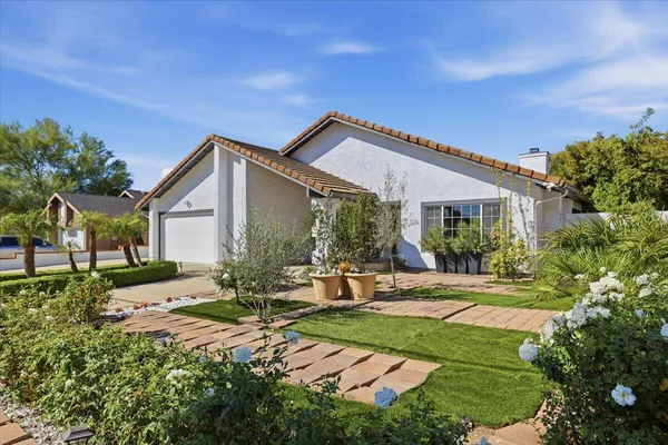 a view of a house with backyard and sitting area