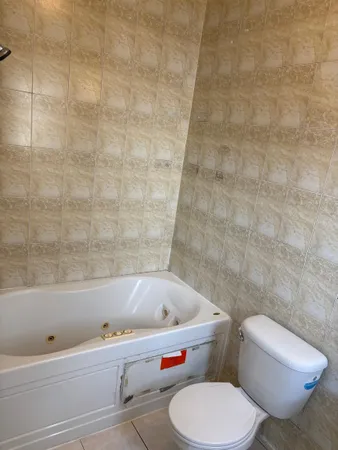 a white toilet sitting next to a bath tub