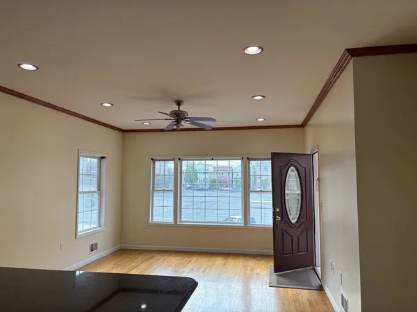 a view of an empty room with a window and wooden floor