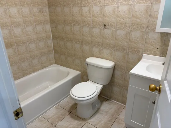 a white toilet sitting next to a bath tub
